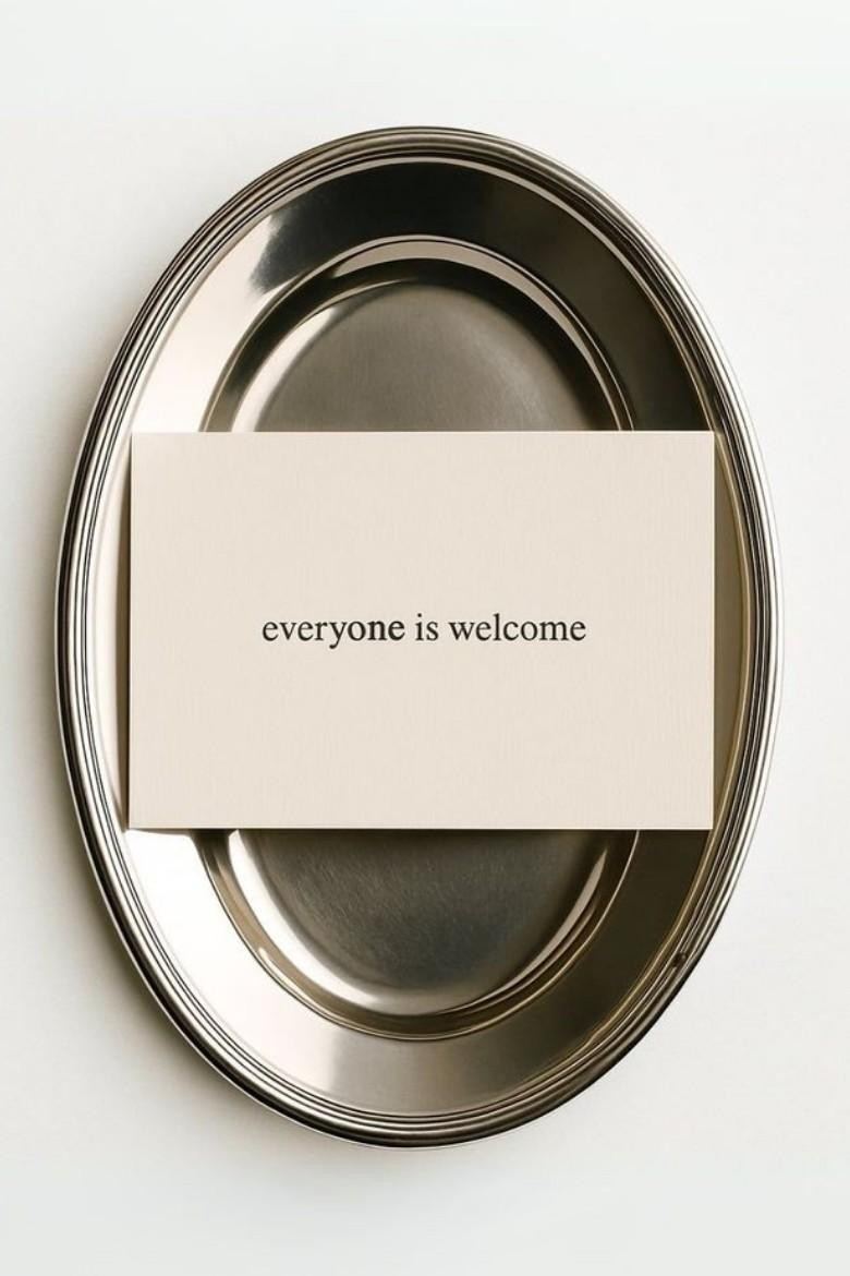 Bandeja metálica con una tarjeta que dice «everyone is welcome»